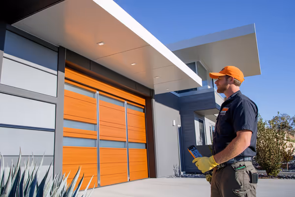 An expert technician conducting a thorough inspection of a garage door, ensuring components function smoothly, in a modern residential setting.